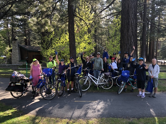 Volunteers picking up litter along a bike path.